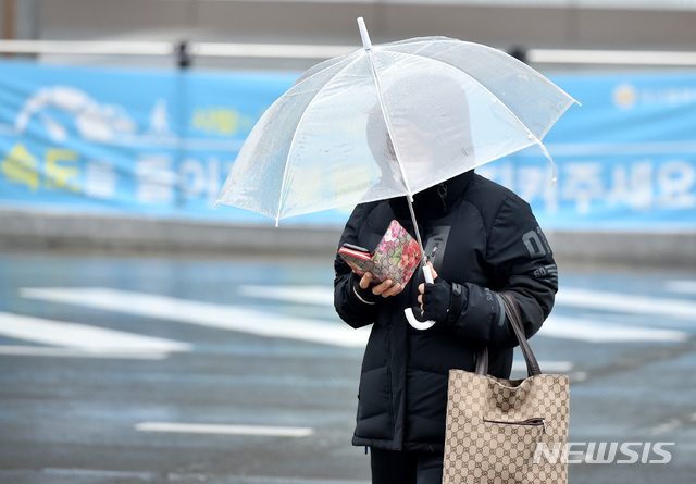【대구=뉴시스】우종록 기자 = 비가 내리고 있는 31일 오전 대구 동구 신천동 동대구역 복합환승센터 앞 횡단보도에서 시민들이 우산을 쓰고 발걸음을 재촉하고 있다. 2019.01.31.wjr@newsis.com