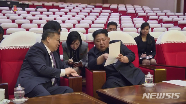 【서울=뉴시스】 북한 조선중앙TV는 2일 북한 친선예술단이 지난달 중국 베이징 방문 영상을 편집한 기록영화를 방영한 가운데 예술단이 출발하기 전 예행연습 현장을 찾은 북한 김정은 국무위원장이 리진쥔(李進軍) 북한 주재 중국대사와 대화를 나누고 있는 모습을 보도하고 있다. 오른쪽은 현송월 삼지연 관현악단장이 객석에 앉아 있다. 2019.02.02. (사진=조선중앙TV 캡쳐) photo@newsis.com