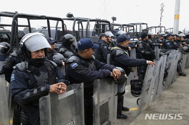 【피에드라스 네그라스( 멕시코) = AP/뉴시스】 멕시코 연방경찰이 진압장비를 갖춘 채 중미이민들의 임시수용소 밖을 지키고 있다.&nbsp; 