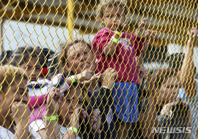 【피에드라스네그라스=AP/뉴시스】2월5일(현지시간) 멕시코 피에드라스네그라스의 이민자 대피소 울타리를 통해 이민 가족들이 건너편을 보고 있다. 2019.06.05. 