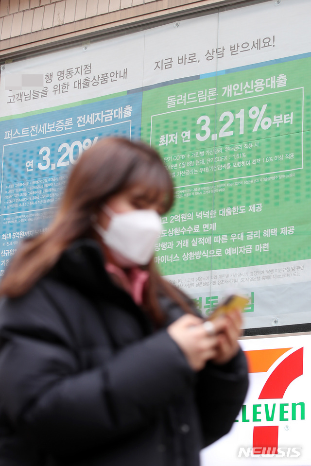 【서울=뉴시스】박미소 수습기자 = 지난달 오전 서울 중구의 한 은행 창문에 붙어진 대출 안내문 앞을 한 시민이 지나고 있다. 2019.02.06. misocamera@newsis.com