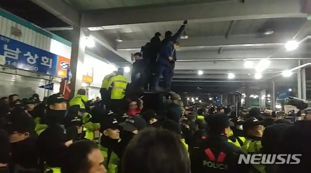 【서울=뉴시스】노량진 구(舊) 수산시장 상인들과 대립을 이어가고 있는 수협 측이 지난 8일 시장의 차량 통행로를 막으면서 상인 측과 격렬한 몸싸움이 벌어지고 있다. 이날 양측은 총 3차례 이상 유리조각을 던지고 주먹다짐을 벌이는 등 강하게 충돌했다. 2019.2.8 photo@newsis.com