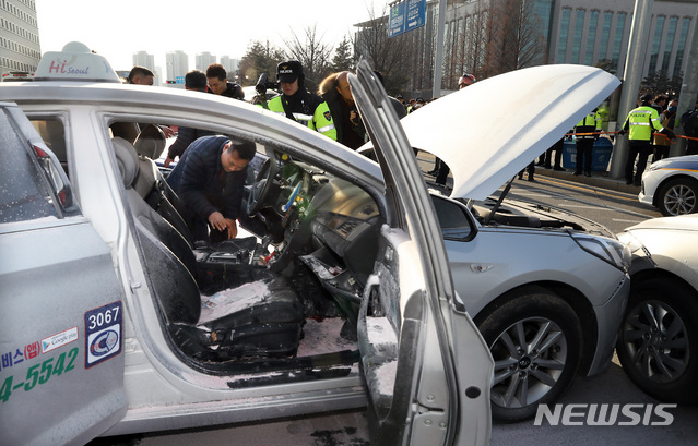 【서울=뉴시스】이종철 기자 = 11일 서울 여의도 국회 앞에서 택시 기사의 분신으로 추정되는 화재사고가 또 다시 발생했다. 택시 기사는 인근 병원으로 후송됐고 관계자들이 택시를 살펴보고 있다. 2019.02.11. jc4321@newsis.com