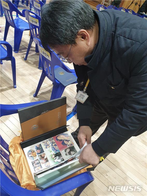 【안산=뉴시스】 이승호 기자 = 12일 오전 경기 안산 단원고에서 세월호 희생학생 명예 졸업식이 끝난 뒤 유경근 4·16세월호참사가족협의회 집행위원장이 딸의 모습이 담긴 졸업 앨범을 펼치고 있다.2019.02.12. jayoo2000@newsis.com