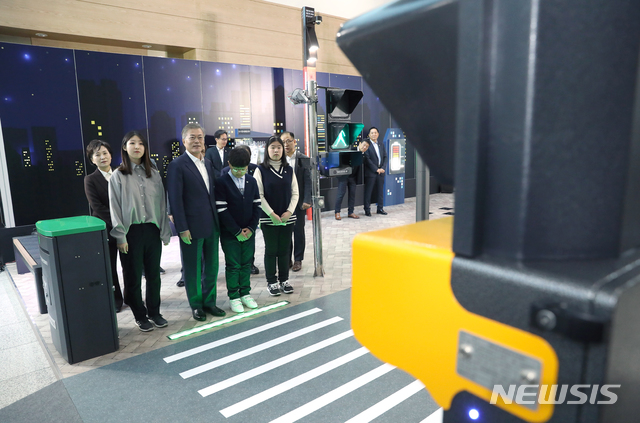 【부산=뉴시스】전신 기자 = 문재인 대통령이 13일 부산 해운대구 벡스코에서 열린 스마트시티 혁신전략 보고회 '혁신의 플랫폼 함께 만드는 스마트시티'에서 대경이엔씨의 스마트 신호등과 횡단보도를 살펴보고 있다. 2019.02.13. photo1006@newsis.com