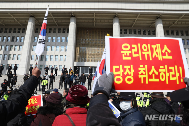 【서울=뉴시스】고승민 기자 = 5.18 폄훼 망언으로 물의를 빚은 자유한국당 김진태, 김순례, 이종명 의원을 징계하는 여부를 논의하는 당 윤리위원회가 모처에서 비공개로 열린 13일 오후 서울 여의도 국회 본청 앞으로 김진태 의원을 비호하는 '태극기 부대' 회원들이 진입, 불법 집회를 하며 성조기 등을 들고 김 의원 등에 대한 윤리위 제소 철회를 촉구하고 있다. 2019.02.13.kkssmm99@newsis.com