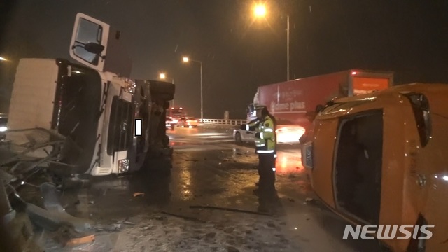 【서울=뉴시스】15일 오전 5시30분께 서울 올림픽대로 염창교 인근에서는 김모(55)씨가 몰던 22t짜리 탱크로리가 차선을 바꾸다 눈길에 미끄러져 옆으로 넘어졌다.2019.02.15(사진=강서소방서 제공)