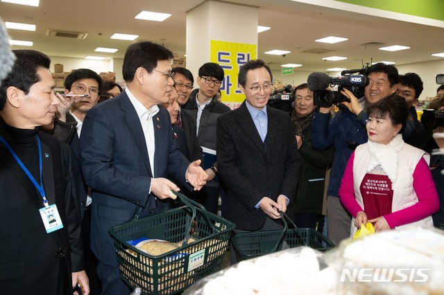 【서울=뉴시스】최종구 금융위원장이 18일 전북 군산 공설시장에서 송하진 전북도지사와 정월대보름을 맞아 물품을 구입하고 있다. 2019.02.18. (사진=금융위원회 제공) photo@newsis.com