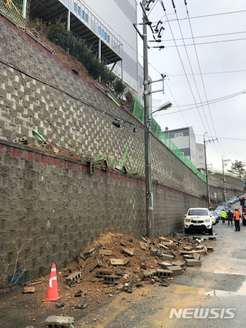 【부산=뉴시스】&nbsp; 19일 낮 12시 45분께 부산 사하구의 한 유통회사 축대가 가로 10m, 세로 5m 크기로 붕괴돼 토사 등이 아래 도로로 쏟아졌다.2019.02.19. (사진=부산경찰청 제공)photo@newsis.com