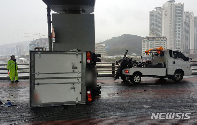 【부산=뉴시스】 19일 오전 11시 35분께 부산 광안대교 하판 해운대 방향으로 달리던 냉동탑차가 오른쪽 난간을 들이받은 뒤 뒤따라오던 트럭과 충돌하고 옆으로 넘어졌다. 2019.02.19. (사진=부산경찰청 제공)photo@newsis.com