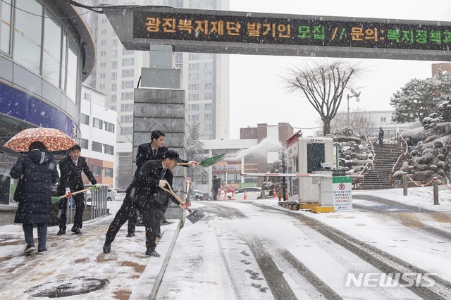 [서울=뉴시스] 지난해 서울 지역 대설특보가 발효한 가운데 광진구청 앞에서 직원들이 염화칼슘을 살포하고 있다. (사진=뉴시스 DB). photo@newsis.com