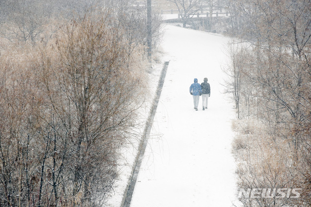 【서울=뉴시스】박미소 수습기자 = 눈이 내리는 19일 오전 서울 영등포구 인근 공원에서 시민들이 산책을 하고 있다.2019.02.19.&nbsp; misocamera@newsis.com