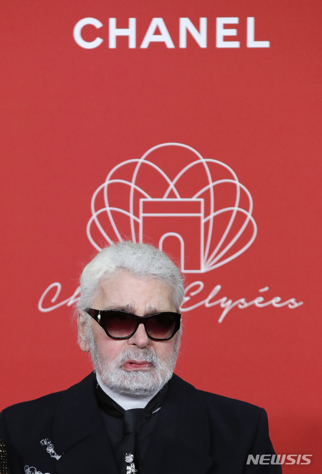 【파리=AP/뉴시스】지난 50년간 디자인뿐 아니라 자신의 트레이드마크인 흰색 말총머리, 풀 먹인 빳빳한 옷깃, 수수께끼의 짙은 안경으로 하이패션업계를 주름잡았던 샤넬의 상징적인 패션 디자이너 카를 라거펠트가 85세의 나이로 별세했다. 사진은 지난해 11월22일 파리 샹젤리제 거리 조명행사장에 모습을 나타낸 라거펠트. 2019.02.19.