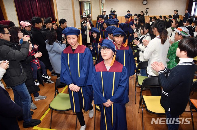 【부산=뉴시스】 하경민 기자 = 오는 3월 1일 폐교하는 부산 사하구 감정초등학교에서 20일 마지막 졸업식과 재학생 수료식이 열렸다. 사진은 졸업생들이 가족돠 후배들의 축하를 받으며 행사장에 입장하는 모습. 이 학교 학생 66명 중 이날 졸업한 15명을 제외한 나머지 학생은 인근 서천초로 전학할 예정이다. 2019.02.20. yulnetphoto@newsis.com