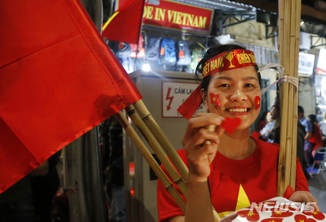 【하노이=AP/뉴시스】지난 1월23일 중국서 열린 U23 축구 결승 진출을 기념해 하노이에 거리 응원이 펼쳐진 가운데 한 여성이 금성홍기를 판매하고 있다. 2019.02.21.
