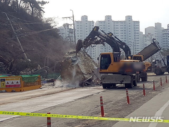 【부산=뉴시스】 하경민 기자 = 지난 2월 22일 부산 사상구 엄궁동과 사하구 하단동 사이 지하철 공사구간 옆 승학산 산비탈 절개지에서 붕괴 우려가 나타나 주변 도로를 경찰이 통제 중인 가운데 산 위에서 큰 바위가 도로로 굴러 떨어졌다. 2019.04.24. (사진=부산경찰청 제공)yulnetphoto@newsis.com