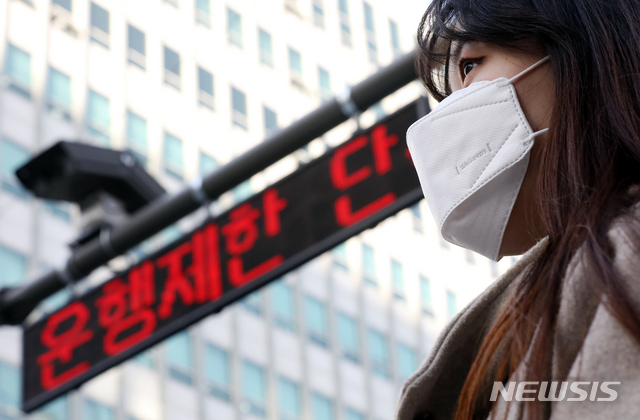 【서울=뉴시스】김병문 수습기자 = 서울 중구 서소문동 일대에서 마스크를 착용한 시민 뒤로 노후차량 운행 단속 CCTV가 보이고 있다. 2019.02.22.  dadazon@newsis.com