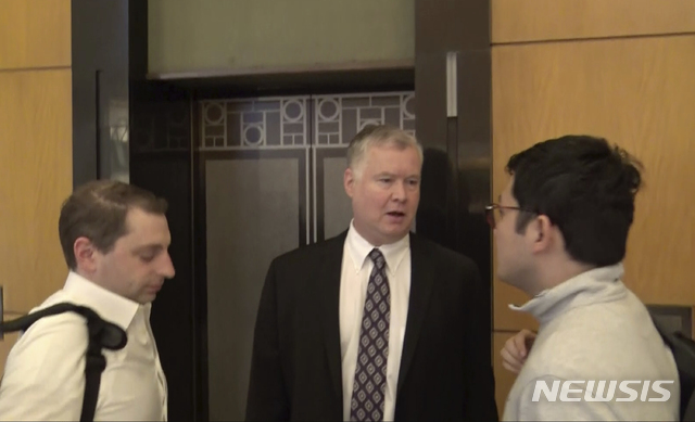 【하노이=AP/뉴시스】스티브 비건(가운데) 미 국무부 대북 특별대표가 22일(현지시간) 베트남 하노이의 한 건물 엘리베이터 앞에서 일행과 얘기를 나누고 있다.  비건 특별대표는 김혁철 북한 국무위원회 대미 특별대표와 제2차 북미 정상회담을 앞두고 이틀째 협상을 벌여 양측이 협상 속도를 높여가고 있다는 관측이다. 2019.02.22. 