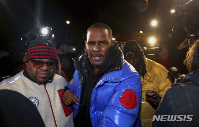 【시카고=AP/뉴시스】 10대 미성년자들에 대한 성범죄 혐의를 받고 있는 가수 알 켈리(R. Kelly)가 22일(현지시간) 경찰서에 도착해 카메라 세례를 받고 있다. 켈리는 이날 10개 이상의 성폭력 범죄 혐의로 구속 기소됐다. 2019.02.24 
