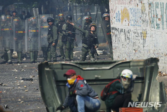  【우레나=AP/뉴시스】23일(현지시간)베네수엘라 우레나에서 시민과 군이 충돌한 가운데 국경수비대가 시위대를 향해 최루탄을 던지고 있다.&nbsp; 이날 새벽 콜롬비아 접경지역인 베네수엘라 우레나에서는 구호 물품을 반입하려는 야당 인사들과 자원봉사자, 시민들이 이를 저지하는 군과 충돌했다.&nbsp; 베네수엘라 국경수비대는 우레나의 국경 다리에서 구호물자 수송을 위한 트럭의 통행을 위해 바리케이드를 치우려는 시민들에게 최루탄을 쏘아댔다. 베네수엘라의 임시 대통령을 자임한 후안 과이도 국회의장은 이날을 인도주의 구호 물품 반입일로 선언한 바 있다. 2019.02.24. 
