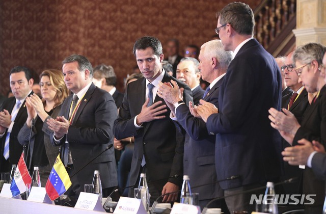 Flanked by Vice President Mike Pence, right center, Venezuela's self-proclaimed interim president Juan Guaido, acknowledges the applause during a meeting of the Lima Group concerning Venezuela at the Foreign Ministry in Bogota, Colombia, Monday, Feb. 25, 2019. (AP Photo/Martin Mejia)
