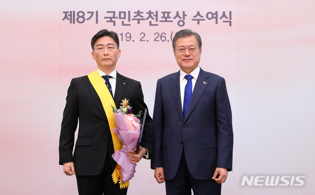 【서울=뉴시스】전신 기자 = 문재인 대통령이 26일 청와대 본관에서 열린 제8기 국민추천포상 수여식에서 이국종 교수(아주대병원 권역외상센터소장)에게 국민훈장 무궁화장을 수여한 후 기념촬영하고 있다. 2019.02.26.&nbsp; photo1006@newsis.com