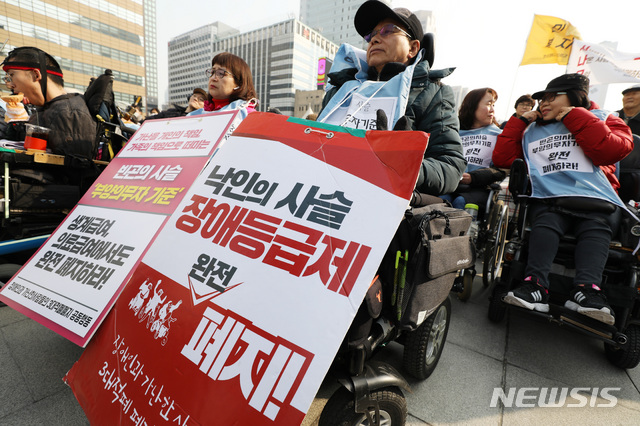 【서울=뉴시스】박미소 기자 = 28일 오후 서울 종로구 광화문 광장 앞에서 열린 '송파 세모녀 5주기 추모제'에서 시민들이 '장애등급제 폐지'와 '부양의무자 기준 폐지'와 관련한 피켓을 들고 있다.  이날 열린 추모제에서 이들은 부양의무자기준의 완전한 폐지 계획과 실질적인 빈곤해결을 위한 대책들을 조속히 수립할 것을 정부에 촉구했다. 2019.02.28.  misocamera@newsis.com