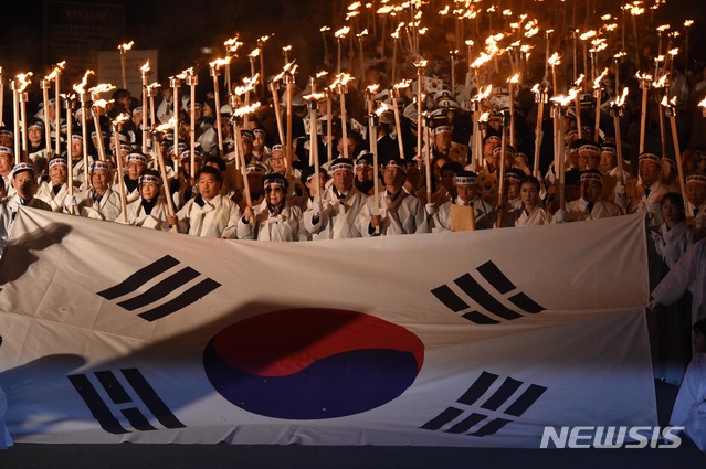 【천안=뉴시스】 함형서 기자 =제100주년 3.1절을 하루 앞둔 28일 오후 충남 천안시 동남구 병천면 사적관리소 앞에서 열린 아우내 봉화제에서 참가자들이 대형태극기를 앞세우며 횃불을 들고 행진을 하고 있다. 2019.02.28.foodwokr23@newsis.com