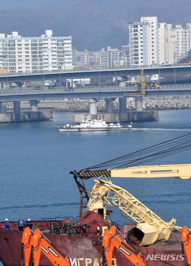 【부산=뉴시스】 하경민 기자 = 1일 부산 남구 용호부두에 정박 중인 러시아 화물선 '씨그랜드호'(5998t·승선원 15명)의 승선원들이 파손된 선박 구조물을 살펴보고 있는 가운데 이 선박이 충돌한 광안대교 하판에서 부산시설공단 관계자들이 안전점검 등을 하고 있다. 2019.03.01. yulnetphoto@newsis.com