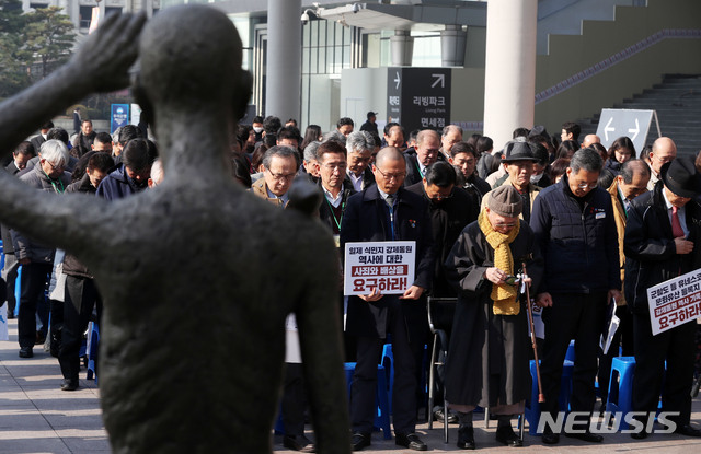 【서울=뉴시스】홍효식 기자 = 지난해 3월 1일 오전 서울 용산역 강제징용노동자상 앞에서 열린 3.1운동 100주년 강제징용노동자상 합동 참배행사에서 1941년 신일철주금 강제징용 피해자인 이춘식 할아버지와 김주영 한국노총 위원장, 김명환 민주노총 위원장을 비롯한 참석자들이 묵념하고 있다. 2019.03.01. yesphoto@newsis.com