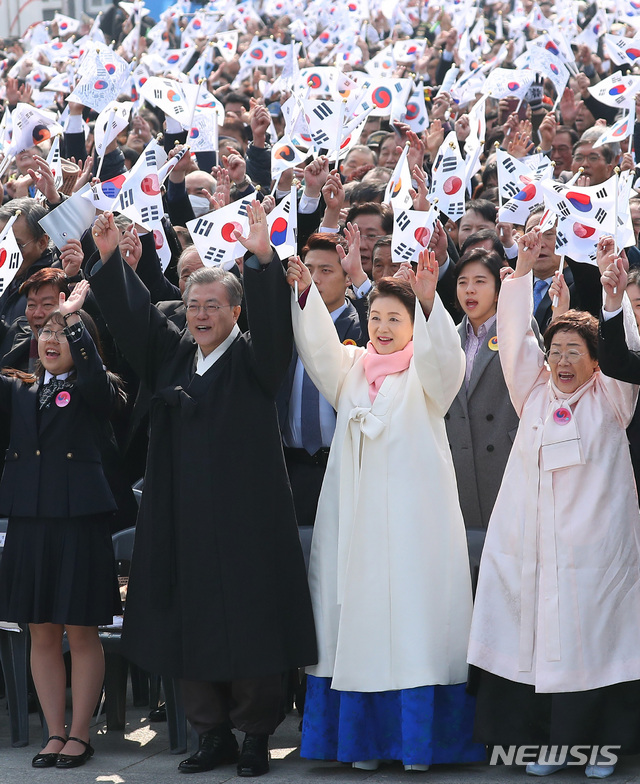 【서울=뉴시스】전신 기자 = 문재인 대통령과 부인 김정숙 여사가 1일 서울 광화문광장에서 열린 제100주년 3.1절 기념식에서 태극기를 흔들며 만세 삼창을 하고 있다. 2019.03.01. photo1006@newsis.com