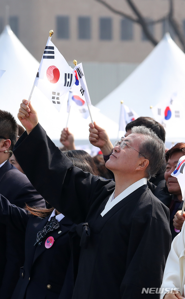 【서울=뉴시스】전신 기자 = 문재인 대통령이 1일 서울 광화문광장에서 열린 제100주년 3.1절 기념식에서 만세삼창을 마친 후 태극기를 흔들고 있다. 2019.03.01. photo1006@newsis.com