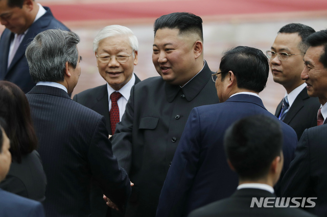 【 하노이=AP/뉴시스】김정은 북한 국무위원장이 1일 베트남 하노이 주석궁을 방문해 응우옌 푸 쫑 공산당 서기장 겸 국가주석(왼쪽 안경 쓴 사람)이 지켜보는 가운데 정부 인사들과 악수하고 있다. 2019.03.01AP)