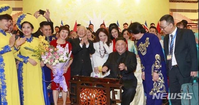 【서울=뉴시스】 김정은 북한 국무위원장이 1일 하노이 국제컨벤션센터(ICC) 환영만찬 자리에서 베트남 전통악기를 연주하며 함박웃음을 짓고 있다. 베트남 외교부는 2일 트위터에 "응우옌 푸 쫑 공산당 서기장 겸 국가주석은 김정은 위원장을 위한 만찬을 열었다"는 글과 함께 사진을 게시했다. 가수 홍늉(흰옷)은 "김 위원장은 노래가 끝나자 일어나서 박수를 쳤다"며 당시의 화기애애한 분위기를 전했다. (사진=베트남 외교부 트위터 캡처) 2019.03.02