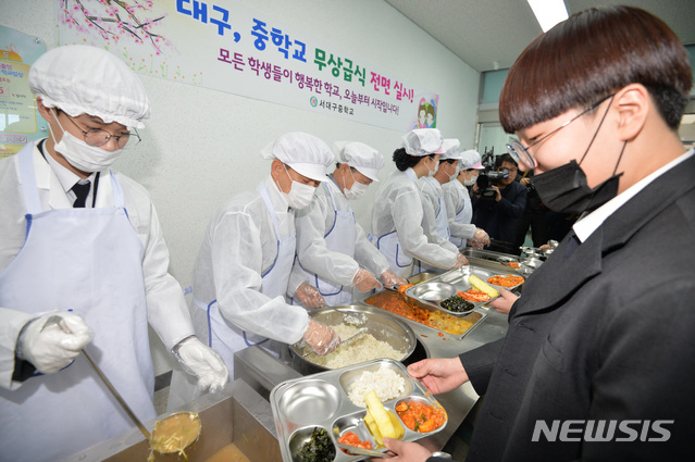 【대구=뉴시스】우종록 기자 = 중학교 무상급식이 전면 실시된 4일 낮 대구 서구 비산동 서대구중학교 식생활관에서 권영진 대구시장을 비롯한 참석자들이 학생들에게 점심을 배식하고 있다. 2019.03.04.wjr@newsis.com