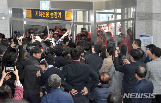 【진주=뉴시스】정경규 기자 = 5일 경남 진주 시내버스인 삼성교통 노조원들이 진주시청 보조 출입문을 부수고 시청 로비로 진입하려다 직원들과 대치하고 있다.2019.03.05. jkgyu@newsis.com