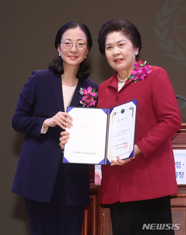 【서울=뉴시스】조수정 기자 = 6일 오후 서울 광진구 능동 유니버설아트센터에서 열린 세계평화여성연합 문연아 세계회장 이임, 문훈숙 세계회장 겸 한국회장 취임식에서 문훈숙(왼쪽) 신임 회장이 김수연 한국회장에게 임명장을 수여한 뒤 기념촬영 하고 있다. 2019.03.06. chocrystal@newsis.com