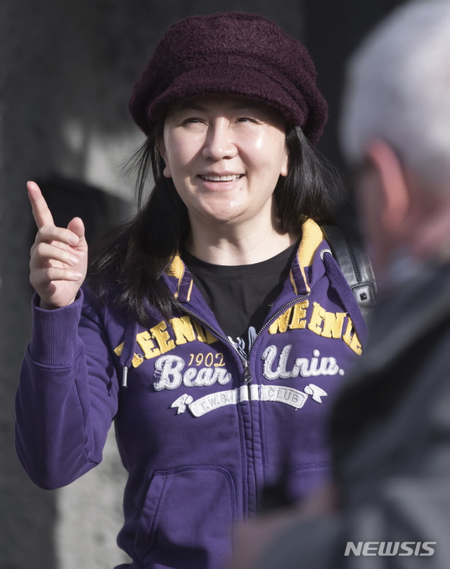  【밴쿠버=AP/뉴시스】멍완저우 화웨이 최고재무책임자(CFO) 겸 부회장이 6일(현지시간) 캐나다 밴쿠버의 브리티시컬럼비아 대법원에서 열린 '범죄인 인도 심리' 출석을 위해 환한 모습으로 집을 나서고 있다.&nbsp;&nbsp; 이날 심리에서 멍 부회장의 변호인 측은 미·중 무역전쟁 와중에 일어난 멍 부회장의 체포가 '정치적 목적'이라는 주장을 우회적으로 피력했다고 현지 언론이 전했다. 2019.03.07. 