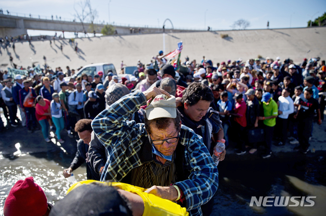 【티후아나( 멕시코) = AP/뉴시스】지난 해 11월 25일 멕시코 경찰이 쳐놓은 저지선을 뚫고 미국 국경을 향해서 행진을 계속하는 중미 이민들의 캐러밴 행렬. 2019.03.29&nbsp;&nbsp; 