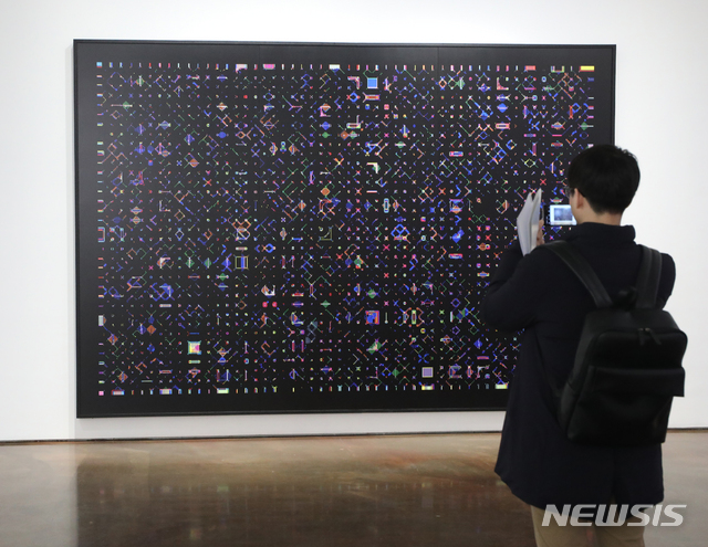 【서울=뉴시스】조수정 기자 = 한국 아방가르드 사진 선구자인 황규태 작가 개인전 '픽셀(Pixel)' 전시 간담회가 열린 7일 오후 서울 소격동 아라리오갤러리 서울 삼청에서 한 참석자가 작품을 보고 있다. 황규태 '픽셀' 사진전은 7일부터 4월 21일까지 열린다. 2019.03.07. chocrystal@newsis.com