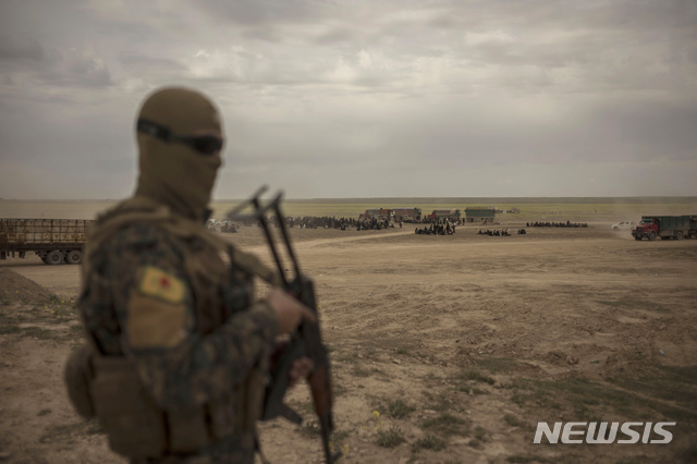 【바구즈(시리아)=AP/뉴시스】6일(현지시간) 시리아 바구즈 외곽 이슬람국가(IS) 무장단체의 마지막 진영에서 '시리아민주군(SDF)'이 경계를 서고 있다. 현지 언론은 시리아민주군이 공세를 늦춘 지난 4일 이후 전투원과 민간인 등 3천500여 명이 동부 데이르에즈조르주 바구즈의 IS 진영에서 빠져나와 SDF에 투항했다고 전했다. 2019.03.07.