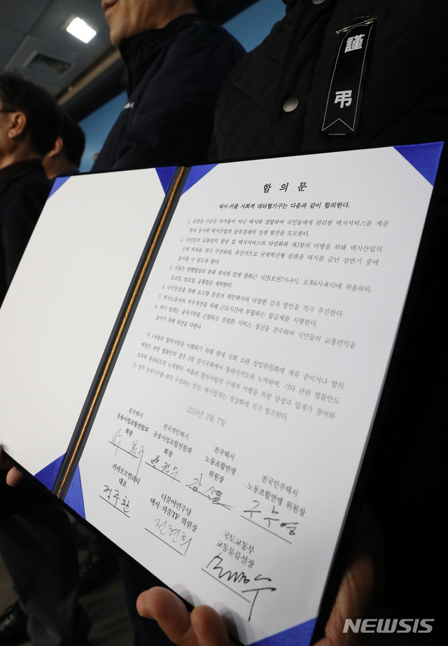 【서울=뉴시스】박영태 기자 = 7일 오후 서울 영등포구 여의도 국회 정론관에서 열린 택시-플랫폼 사회적대타협기구 기자회견에서 참석자가 합의문을 들고 있다. 2019.03.07. since1999@newsis.com