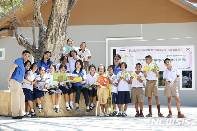 【서울=뉴시스】김가윤 기자 = 삼성엔지니어링 임직원과 태국 농팝마을 아이들이 태국 '희망도서관' 앞에서 기념촬영을 있다. 2019.03.08 (제공=삼성엔지니어링) yoon@newsis.com