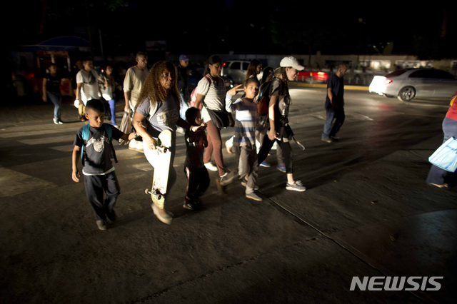 【카라카스=AP/뉴시스】7일(현지시간) 베네수엘라 수도 카라카스가 정전돼 시민들이 깜깜한 거리를 걸어 다니고 있다. 이번 정전으로 카라카스의 많은 직장인이 지하철 운행이 중단돼 걸어서 퇴근하고 신호등이 꺼진 교차로에서는 차량이 서로 엉키는 등 혼선을 빚었다. 현지 관계자는 목요일 발생한 이번 정전이 전력난으로 어려움을 겪고 있는 베네수엘라에서 그간 발생한 정전 중 최악이라고 밝혔다. 2019.03.08.