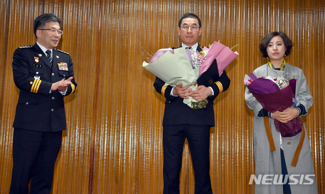 【광주=뉴시스】류형근 기자 = 민갑룡 경찰청장이 8일 오전 광주 북구 북부경찰서 강당에서 열린 이광행 경위 특진 임용식에 참석해 기념사진을 찍고 있다. 이 경위 등 경찰은 지난해 11월 "조직원이 광주지역 조폭에게 폭행을 당했다"는 이유로 원정 복수에 나선 수도권 지역 7개파 35명을 붙잡았다. 2019.03.08. hgryu77@newsis.com