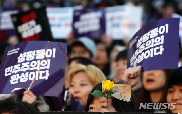 [서울=뉴시스]2019년 세계 여성의 날인 3월8일 오후 서울 종로구 광화문 광장에서 열린 '제35회 한국여성대회'에서 '희망'을 상징하는 노란 장미와 '성평등이 민주주의의 완성이다'라는 문구가 적힌 피켓이 보이고 있다. (사진=뉴시스DB). 2019.03.08. photo@newsis.com