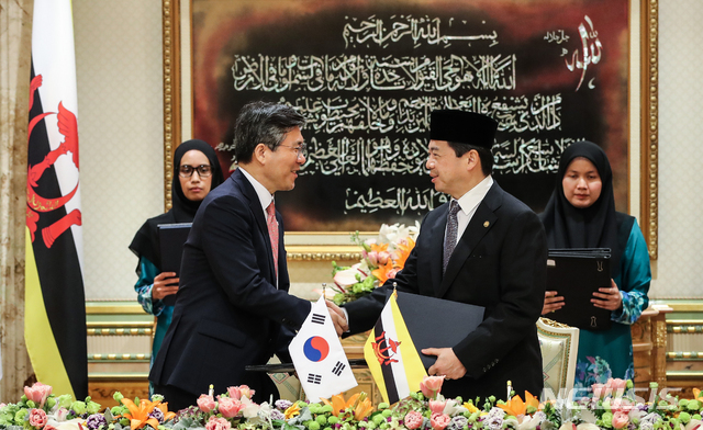 【반다르스리브가완(브루나이)=뉴시스】전신 기자 = 성윤모 산업통상자원부 장관과 아민 리우 압둘라 브루나이 재무경제부 제2장관이 11일 오전 브루나이 왕궁에서 열린 MOU 서명식에서 문재인 대통령과 하사날 볼키아 브루나이 국왕이 지켜보는 가운데 한·브루나이 투자협력 MOU를 체결하고 있다. 2019.03.11. photo1006@newsis.com