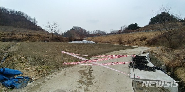 【보은=뉴시스】충북 보은군 삼승면의 한 야산 기슭 밭에 버려진 돼지 사체를 보은군이 비닐 포장 등으로 덮은 뒤 출입을 통제하고 있다.(사진=독자 제공)  photo@newsis.com