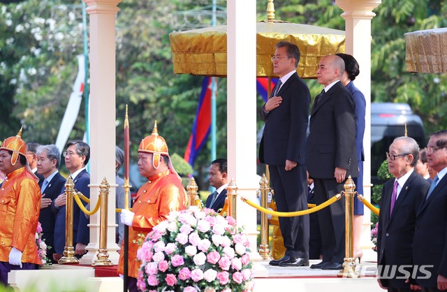 【프놈펜(캄보디아)=뉴시스】전신 기자 = 캄보디아를 국빈 방문 중인 문재인 대통령과 부인 김정숙 여사가 15일 프놈펜 왕궁 정원에서 열린 공식환영식에서 노로돔 시하모니 국왕과 양국 국가 연주를 듣고 있다. 2019.03.15. photo1006@newsis.com