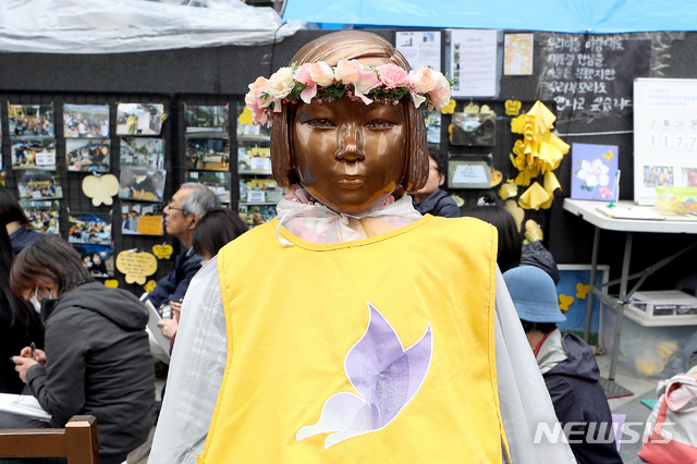 【서울=뉴시스】김병문 기자 = 지난 3월20일 오후 서울 종로구 옛 일본대사관 앞에서 정의기억연대 주최로 열린 일본군 성노예제 문제해결을 위한 제1379회 정기 수요집회가 열리는 가운데 소녀상이 봄을 맞이해 화관을 쓰고 있다. 2019.03.20.&nbsp; dadazon@newsis.com